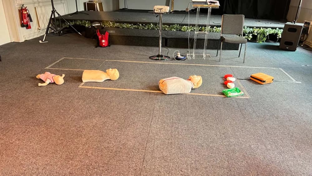 CPR training mannequins and an AED trainer set out in a training room
