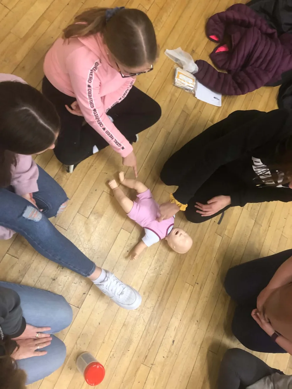 Participants practising infant CPR technique on a training mannequin
